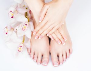 Female feet at salon on pedicure and manicure